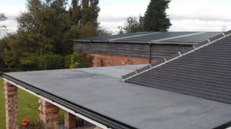 Flat roof connected to shingle roof